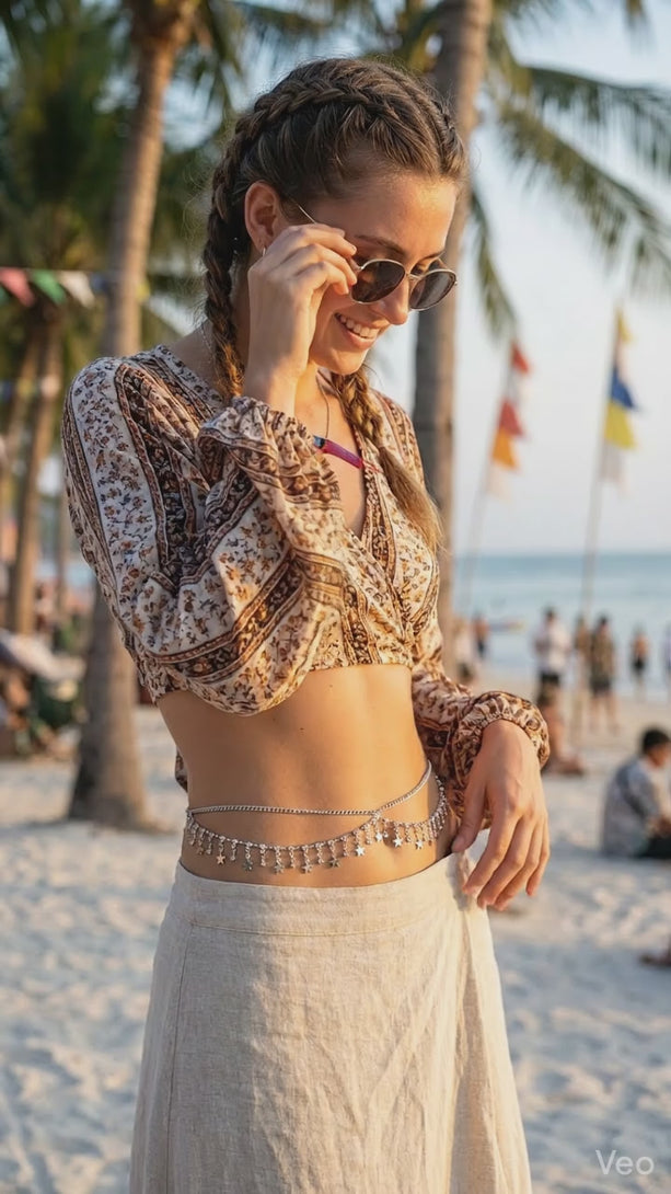 Woman ready for a night out wearing a sparkly crystal belly chain over a form-fitting black dress under evening party lights.