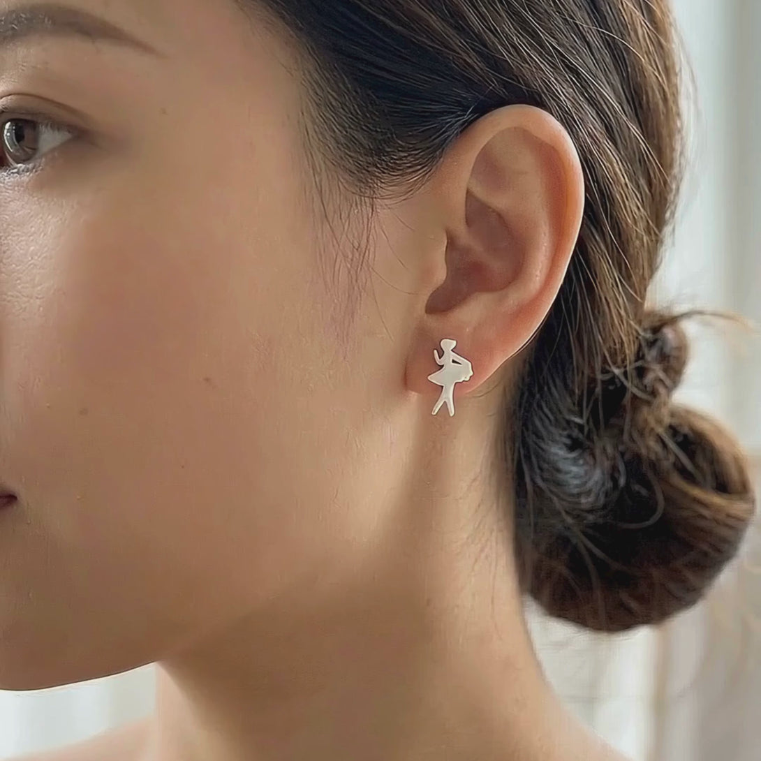 Lifestyle video of a woman in soft-toned casual wear beautifully styling the 925 sterling silver 7 days of the week dainty stud earrings.