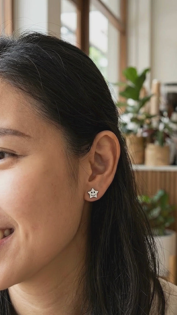 Lifestyle video of a woman in a cozy cafe wearing the dainty celestial silver earrings, perfectly styled with a soft-toned casual outfit.