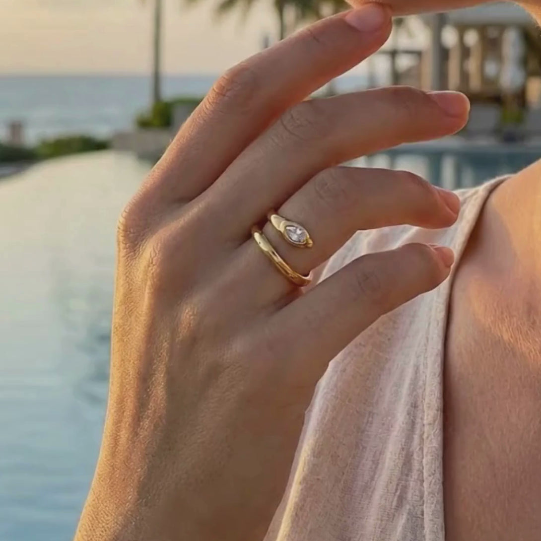 Short video showcasing the reflective 18K gold finish and sparkling CZ of the serpent ring in a luxury resort environment.