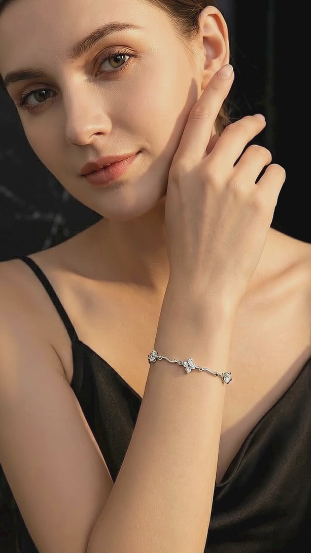 Video of a model in an elegant black evening gown wearing the dazzling S999 Fine Silver Lucky Clover Bracelet, showing how the AAA stones catch the light in motion.