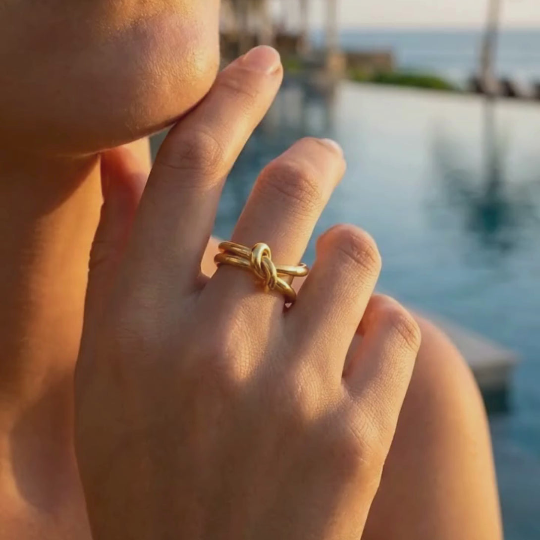 Short video showcasing the waterproof Open Wire Knot Ring's radiant finish and delicate knot design by a resort pool.