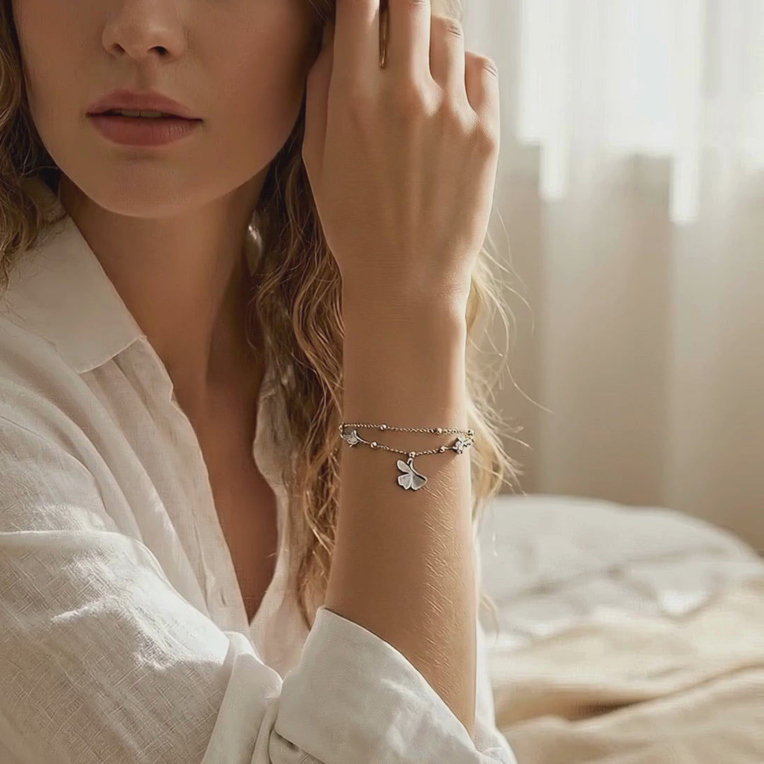 Video showcasing the delicate movement and brilliant shine of the S925 silver ginkgo bracelet on a model's wrist in a warm home environment.